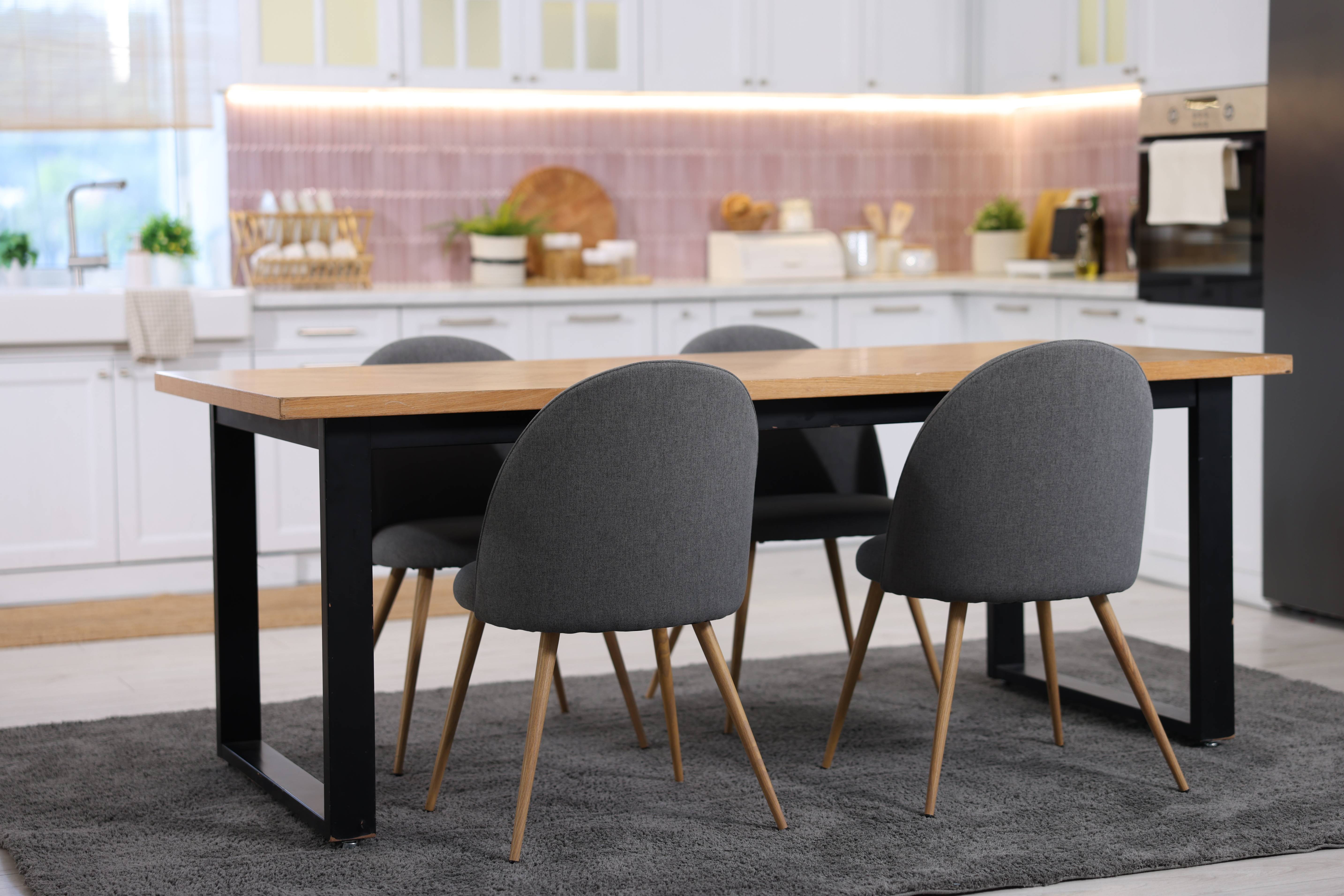 Solid Oak Dining Table with grey upholstered chairs in a modern kitchen dining area.